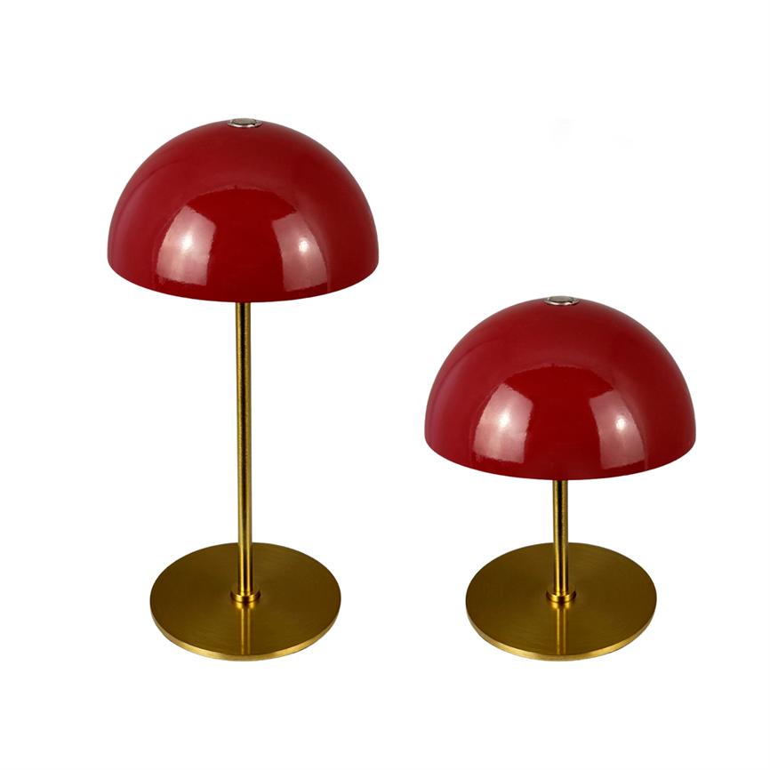 Two round, red table lamps with dome shades stand on slender golden metal stems; one is taller, both on flat round gold bases against white background.