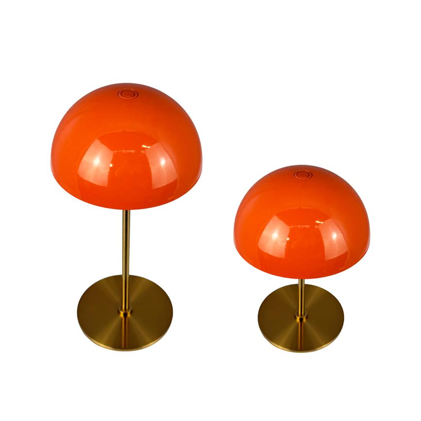 Two shiny orange dome lamps stand on brass shafts in two heights with round bases, placed against a white background as a product display.