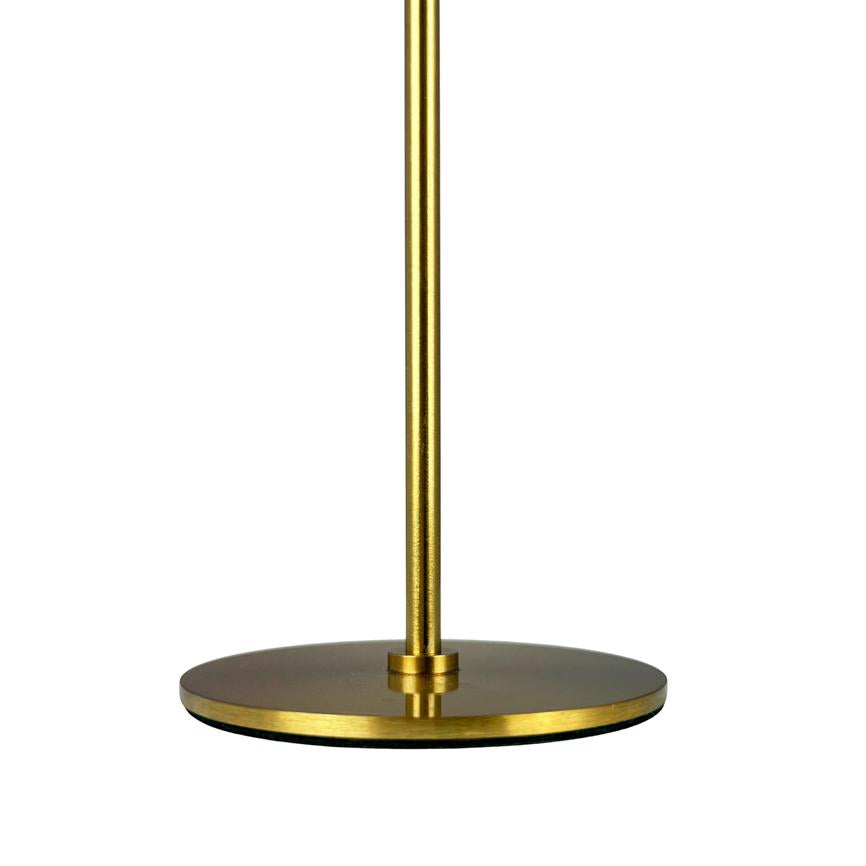 Gold colored lamp post stands vertically; a slim, brushed metal rod is attached to a round, low, flat base with a dark underside on a solid white background.
