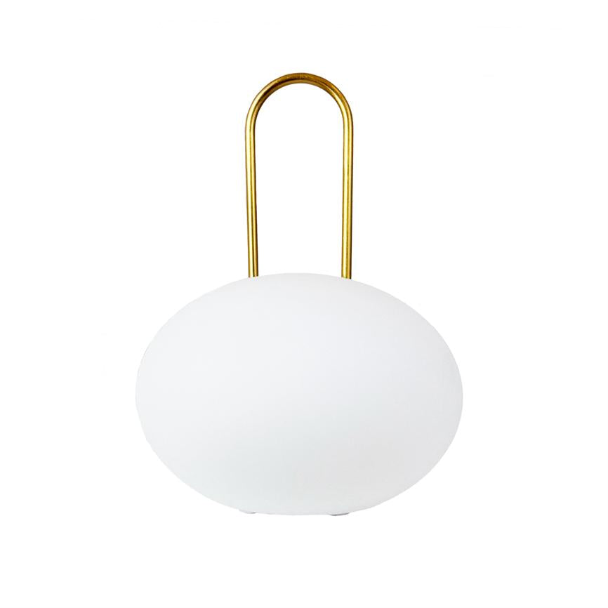 Round white lamp stands on the surface and carries a golden, U-shaped handle; the object is centered against a clean, white background.