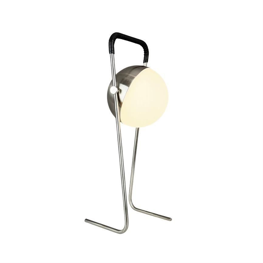 Round lamp glows softly, mounted in a slim chrome stand with two legs and a black handle; the design is isolated in front of a uniform white background.